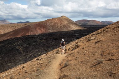Caldera Blanca volkan yamacında kadın yürüyüşçü, Kanarya adası Lanzarote, İspanya