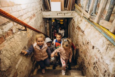 07.07.22 Irpin, Ukraine: small children and their caregivers are evacuated to an underground cellar used as a shelter during an air raid