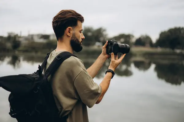 Seorang Pemuda Dengan Kamera Slr Modern Tangannya Pada Latar Belakang Stok Foto