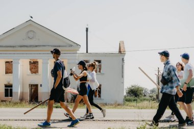 06.08.2022 Irpin, Ukraine:  a group of volunteers is moving in the direction of the house destroyed by the Russian troops to carry out dismantling and restoration of the lost housing