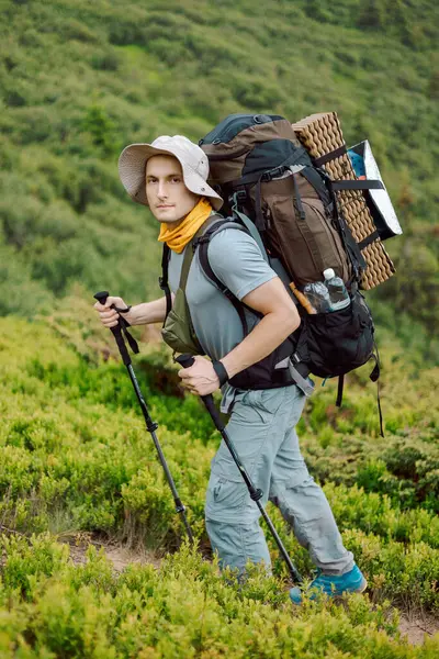 portrait of a hiker with trekking poles and backpack climbing or descending mountain hiking trails