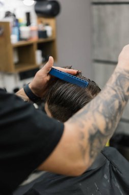 28.11.23 Vinnitsa, Ukrayna: erkeklerin diğer erkekler için çalıştığı erkek saç kesimi için modern bir kuaför salonu. Müşterilerde saç kesme işlemi