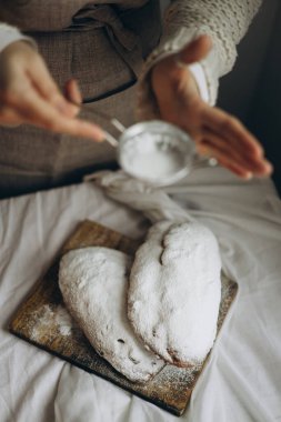 Baharatlı kuru üzüm ve fındıkla çalınmış ev yapımı taze Noel süslenmiş ve üzerine pudra şekeri serpilmiş.