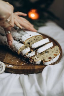 Baharatlı kuru üzüm ve fındıkla çalınmış ev yapımı taze Noel süslenmiş ve üzerine pudra şekeri serpilmiş.