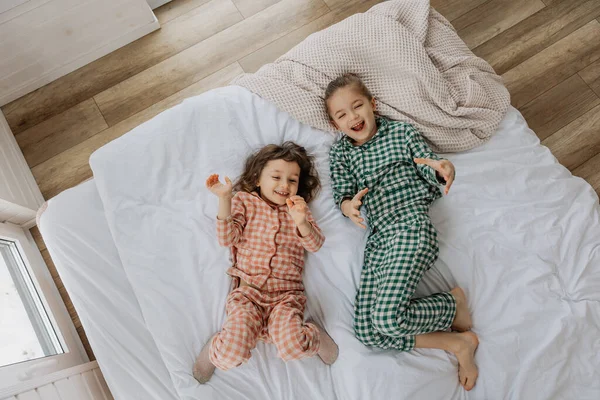 Günaydın çocuklar, en iyi manzara. Mutlu kız kardeşler bir yatakta yatıyor. Sabah uyanan küçük kızlar bir yatakta. 