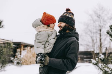 Bir baba ve kızı kış karlı mevsimde evin arka bahçesinde oynuyorlar, karda oynuyorlar ve birlikte bir günlük tatilin tadını çıkarıyorlar.