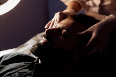 Güzellik, çamur ve nemlendirici maske için kaplıcada sakallı bir adamla yüz bakımı, cilt bakımı ve rahatlama. Sakinlik, masaj ve güzellik salonu için yüzüne sürtünen bir erkek ve kadın güzellik ürünüyle sağlık, terapi ve sağlık.