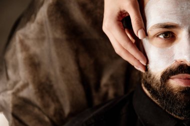 Güzellik uzmanı, spa 'daki yaşlı bir adamın yüzüne masaj uygular.