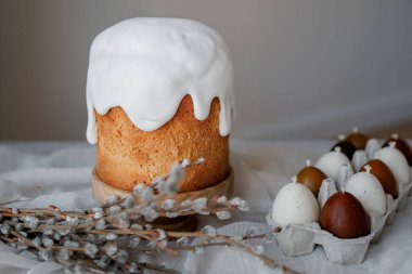 Paskalya pastaları ve şenlikli dekorlarla estetik ve şık bir masa. Paskalya pastası, Paskalya yumurtaları, mumlar. Boşluğu kopyala