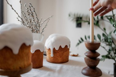 Paskalya pastaları ve şenlikli dekorlarla estetik ve şık bir masa. Paskalya pastası, Paskalya yumurtaları, mumlar. Boşluğu kopyala