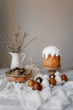 Paskalya pastaları ve şenlikli dekorlarla estetik ve şık bir masa. Paskalya pastası, Paskalya yumurtaları, mumlar. Boşluğu kopyala