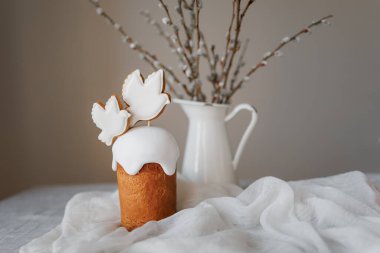 Paskalya pastaları ve şenlikli dekorlarla estetik ve şık bir masa. Paskalya pastası, Paskalya yumurtaları, mumlar. Boşluğu kopyala