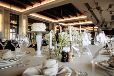 Lüks bir restoranda beyaz pasta süsü olan şık bir masa..