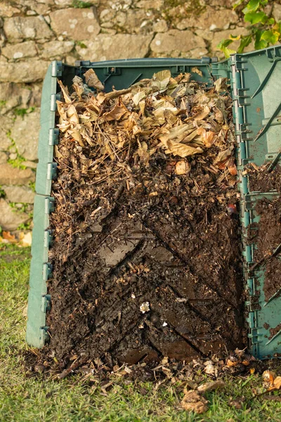 Aşağıdaki kısımda oluşan olgun gübre çıkarmak için açık gübre kutusu açıldı. Kompost kutusu, ev ve bahçede üretilen organik atıkları geri dönüştürmek için bir ev bahçesine yerleştirildi. Geri dönüşüm ve sürdürülebilirlik kavramı