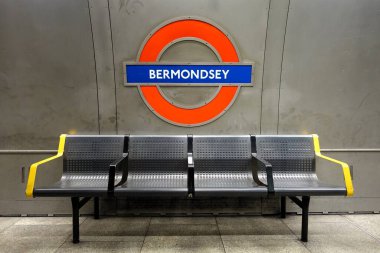 Bermondsey station London Underground roundel sign and seating on tube platform clipart