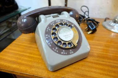 Klasik, ahşap bir masaya yerleştirilmiş eski bir çevirmeli telefon.
