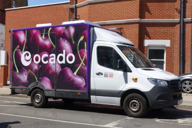 Bir Ocado ev teslimatı aracı markete gidiyor.