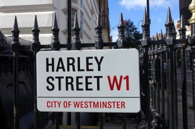 The Harley Street sign is displayed on iron railings in London, England. Harley Street is renowned worldwide for its private medical and healthcare services.