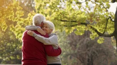 Retired grey-haired man and woman in love hugging outdoor. High quality photo