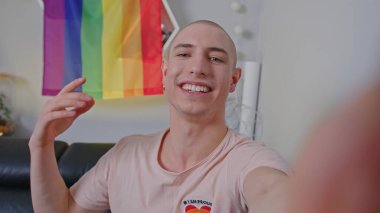 Bald smiling gay man with a rainbow LGBT flag. High quality photo