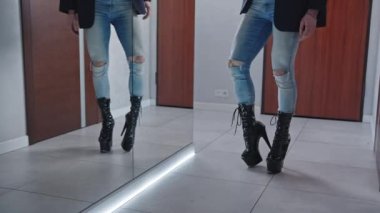 Man on black high heels for pole dance posing in front of the mirror. High quality 4k footage