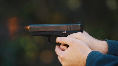 Hands of a man holding a gun Glock and firing. High quality photo