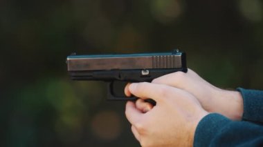 Hands of a man firing a gun Glock, shells dropping. High quality 4k footage