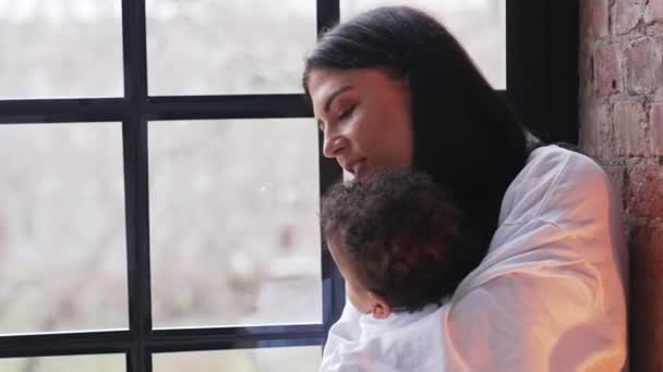 Young Woman Hugging Her Toddler Biracial Son Window High Quality — 图库视频影像