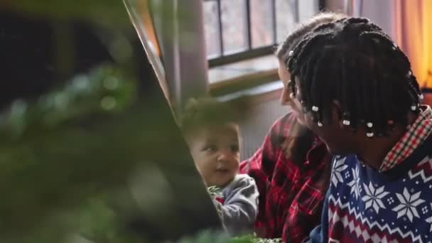 多人種の両親を持つ赤ちゃんの男の子は クリスマス服を着て笑っています 高品質4K映像 — ストック動画