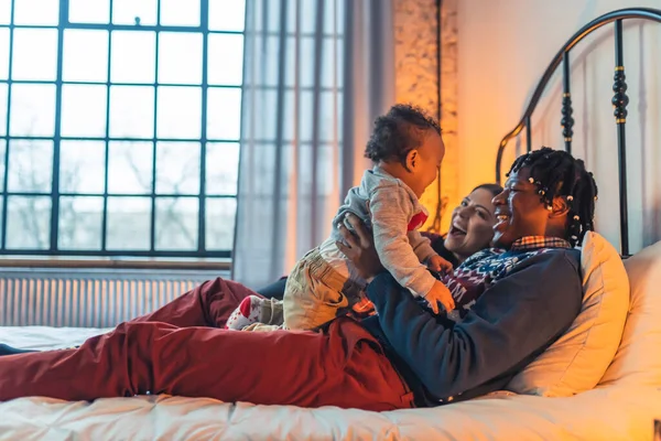 Smiling Multiracial Family Three Cuddling Playing Bed High Quality Photo — Stockfoto
