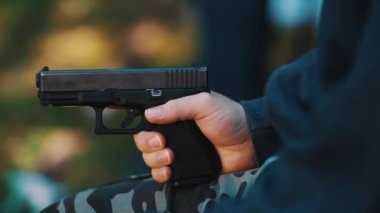 Man holding a gun in his hand. Glock safe, accurate and light pistol for self-defense, slow motion video. High quality 4k footage