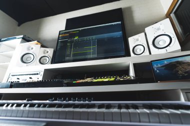 Music production desk with computer, synthsizer and sound mixer at home studio . High quality photo
