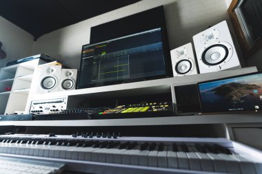 Music production desk with computer, synthsizer and sound mixer at home studio . High quality photo