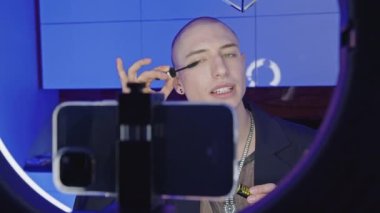 closeup view of a bald gay man making eyelashes in a live video, makeup tutorial LGBT concept. High quality 4k footage