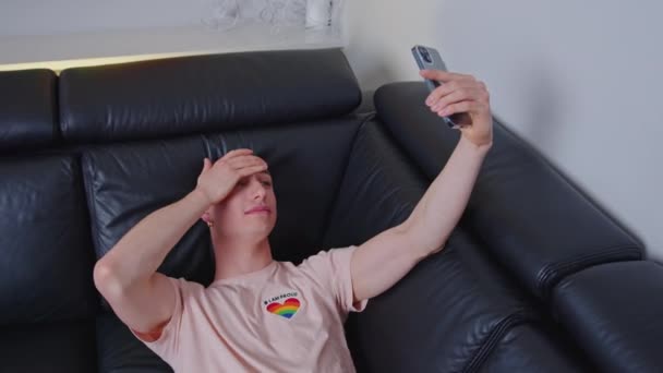 Homem Gay Caucasiano Deitado Sofá Gravando Vídeo Com Seu Telefone — Vídeo de Stock