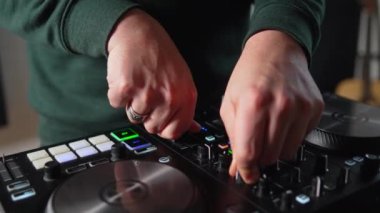 Close up hands turning knobs and pushing buttons on sound mixing board at home recording studio. High quality 4k footage