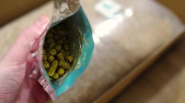 Man holding open vaccum bag with hops pellet. High quality 4k footage