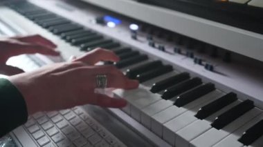 Closeup view of male hands playing synthesizer, pressing keys at home studio. High quality 4k footage