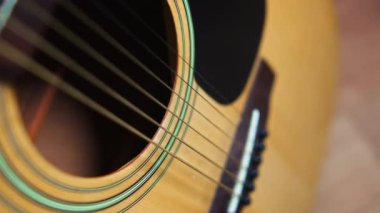 Yakın çekim tahta gitar gövdesi, teller ve ses deliği. Yüksek kalite 4k görüntü