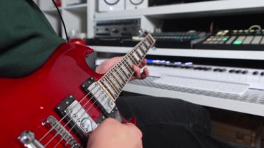 Man playing red electric guitar at music recording home studio. High quality 4k footage