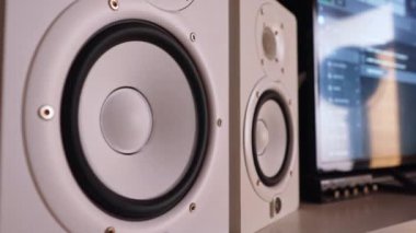 Profesyonel beyaz stüdyo monitörleri titreşiyor, müzik çalıyor. Yüksek kalite 4k görüntü