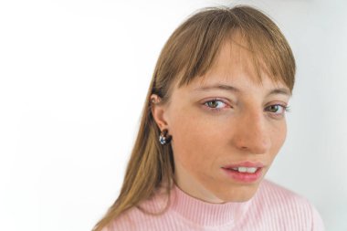 Beyaz arka planda izole bir şekilde kameraya bakan genç beyaz bir kız. Yüksek kalite fotoğraf