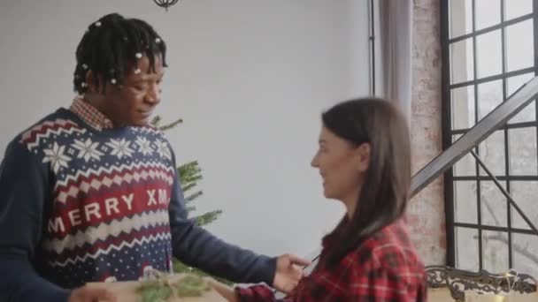 クリスマスにアフリカ系アメリカ人の夫に贈り物をする白人の妻 メリー クリスマス 私の愛する人 メディアの閉鎖 高品質4K映像 — ストック動画