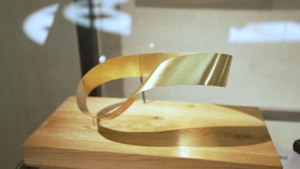 ワルシャワのテクノロジー博物館に展示されている数学的対象である黄金のモービュース ストリップ 高品質4K映像 — ストック動画