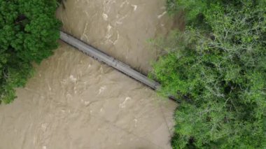 Şiddetli yağmur ve sel ile nehir üzerinde hava aracı görüntüsü.