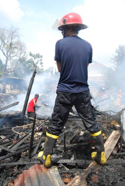 İtfaiyeci ateşle savaşıyor.