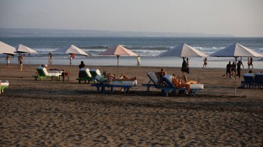 İnsanlar akşamları sahilde.