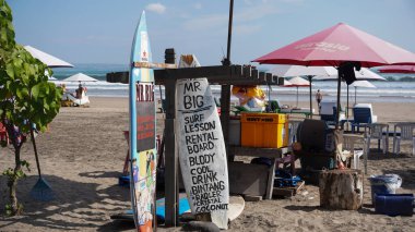 Bali, Endonezya - Temmuz 327: Sahilde renkli şemsiyeli ve güneşli yataklı turistler