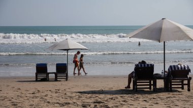 Şapkası ve kumsalı olan bir adam.