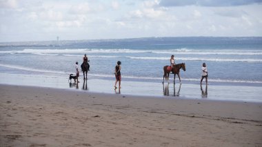 Kumsalda yürüyen insanlar